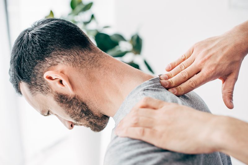 Man receiving neck pain treatment from a chiropractor